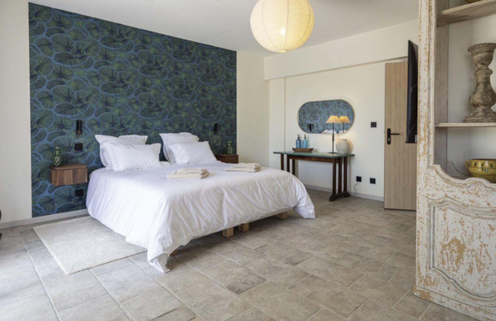 Chambre de luxe N. 1 — le lit sous le papier peint aux feuillages bleus